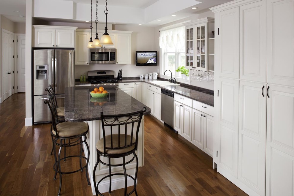 This is an example of a traditional l-shaped kitchen in Boston with raised-panel cabinets and white cabinets.