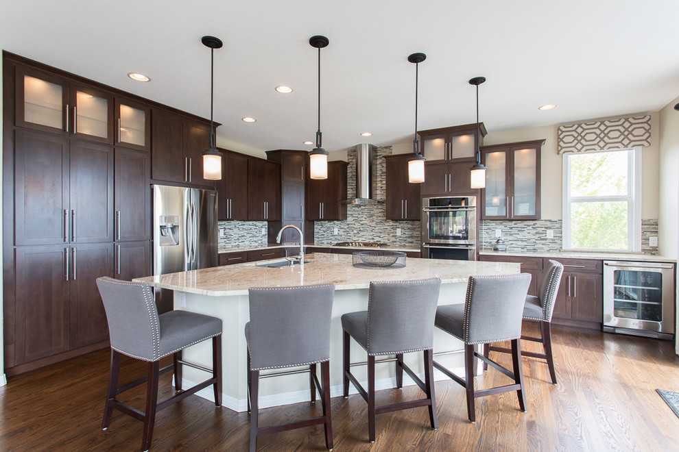 Large transitional l-shaped dark wood floor and brown floor open concept kitchen photo in Denver with an undermount sink, shaker cabinets, dark wood cabinets, granite countertops, metallic backsplash, glass tile backsplash, stainless steel appliances and an island