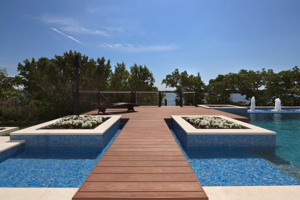 Inspiration for a contemporary custom-shaped pool in Miami with decking.