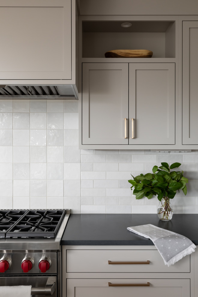 Example of a mid-sized transitional open concept kitchen design in Seattle with shaker cabinets, gray cabinets, quartz countertops, white backsplash, subway tile backsplash, stainless steel appliances, an island and black countertops