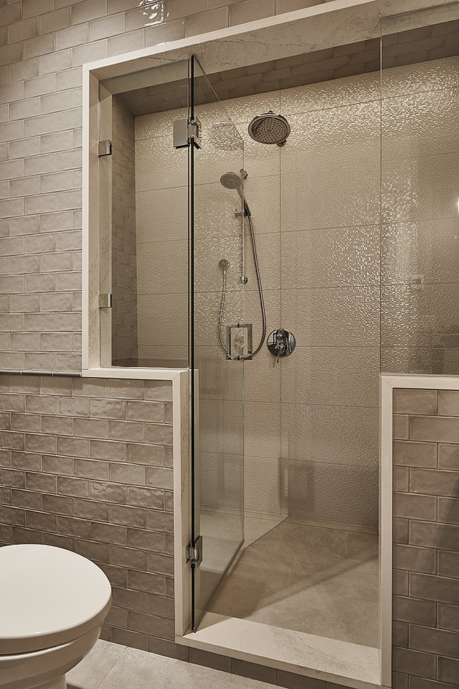 This is an example of a small transitional 3/4 bathroom in Other with gray tile, a corner shower, a one-piece toilet, subway tile and a hinged shower door.