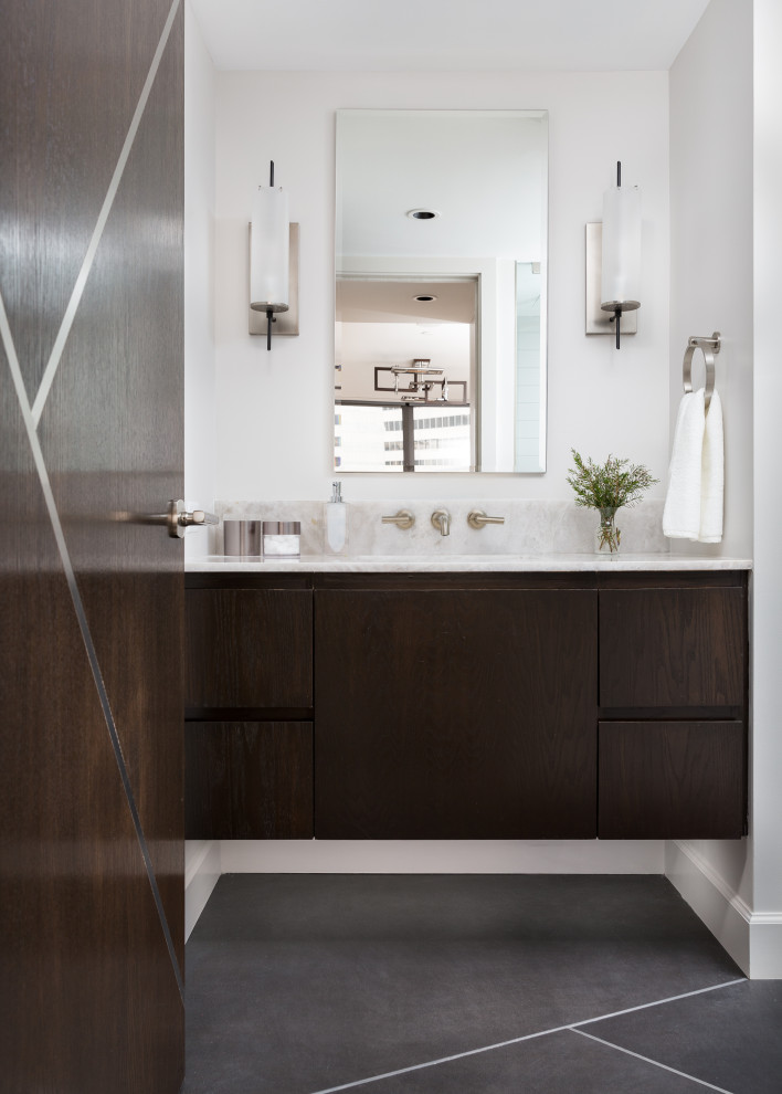 This is an example of a mid-sized contemporary master bathroom in Houston with flat-panel cabinets, an alcove shower, porcelain tile, white walls, porcelain floors, an undermount sink, a niche, a single vanity, a floating vanity, dark wood cabinets, onyx benchtops, white benchtops, a one-piece toilet, black floor, a hinged shower door and gray tile.