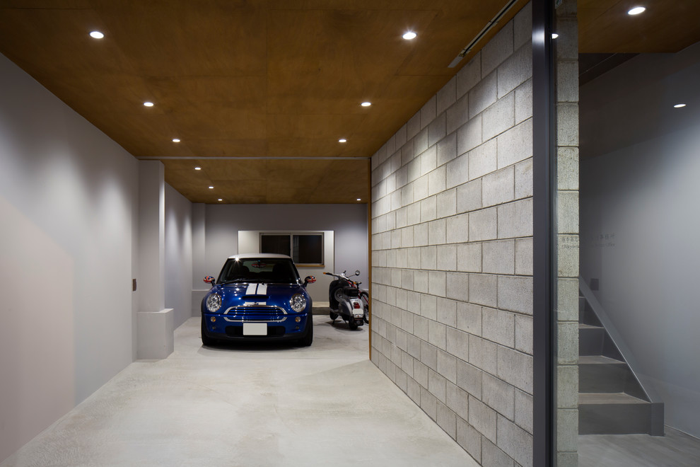 Cette image montre un petit garage pour deux voitures attenant urbain avec un bureau, studio ou atelier.