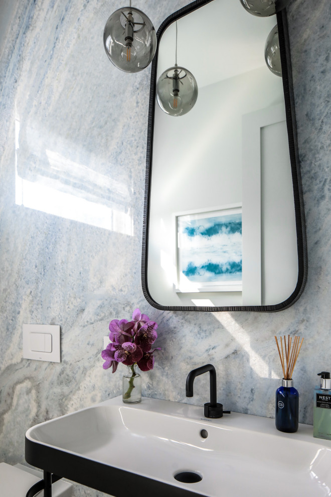 Powder room - modern marble tile powder room idea in New York with open cabinets and a pedestal sink
