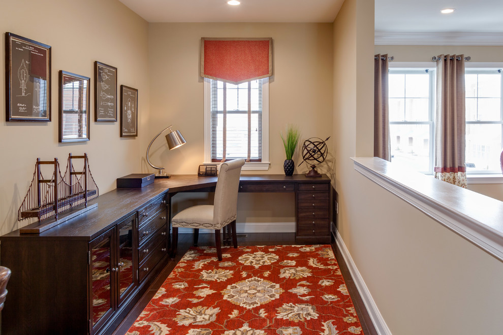 This is an example of a small traditional home office in Philadelphia with beige walls, dark hardwood floors and a freestanding desk.