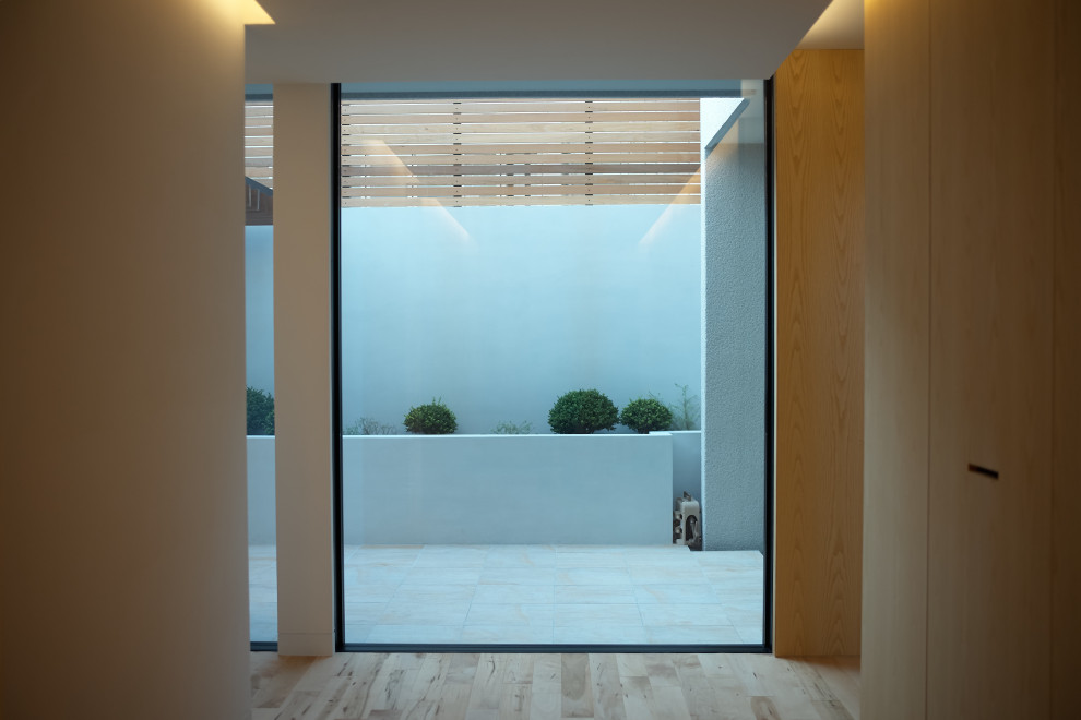 Ejemplo de recibidores y pasillos de estilo zen grandes con suelo de madera en tonos medios y suelo beige