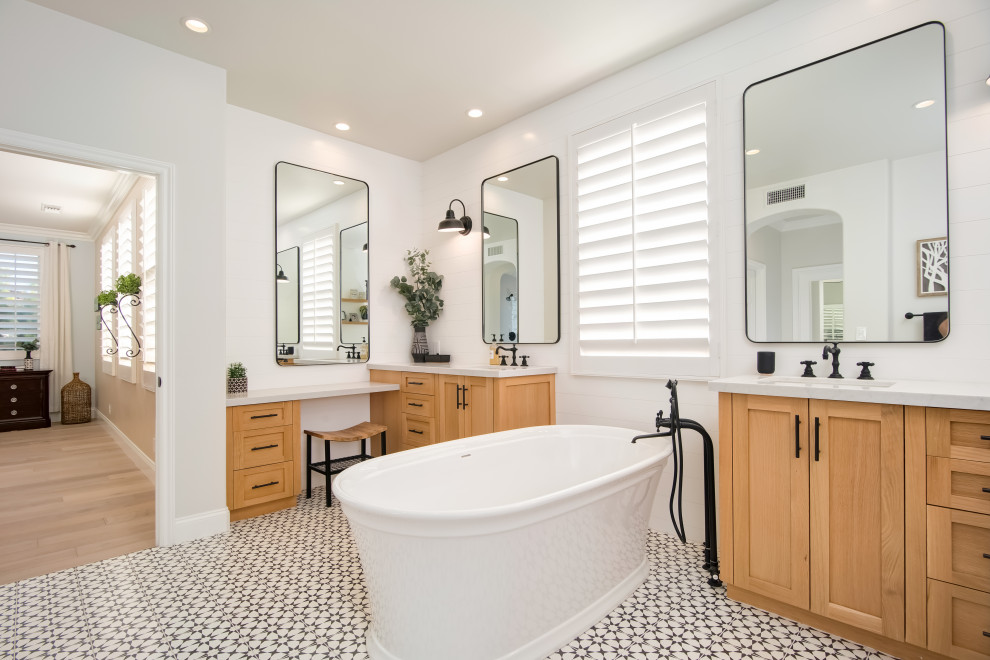 This is an example of a large country master bathroom in Orange County with shaker cabinets, light wood cabinets, a freestanding tub, white walls, cement tiles, an undermount sink, engineered quartz benchtops, white floor and grey benchtops.