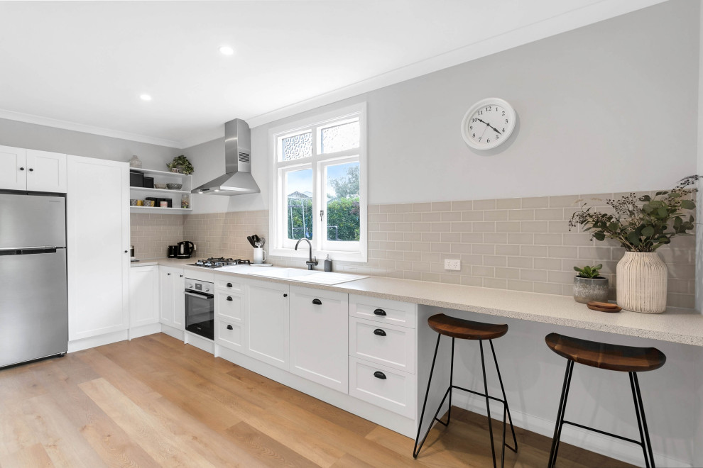 Inspiration for a small traditional l-shaped open plan kitchen in Other with a built-in sink, shaker cabinets, white cabinets, laminate countertops, grey splashback, metro tiled splashback, stainless steel appliances, laminate floors, no island, multi-coloured floors and multicoloured worktops.