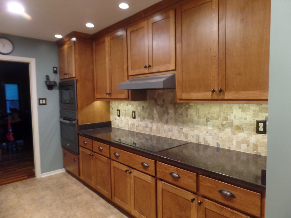 Eat-in kitchen - mid-sized transitional galley eat-in kitchen idea with an undermount sink, shaker cabinets, medium tone wood cabinets, quartz countertops, multicolored backsplash, travertine backsplash, colored appliances and no island