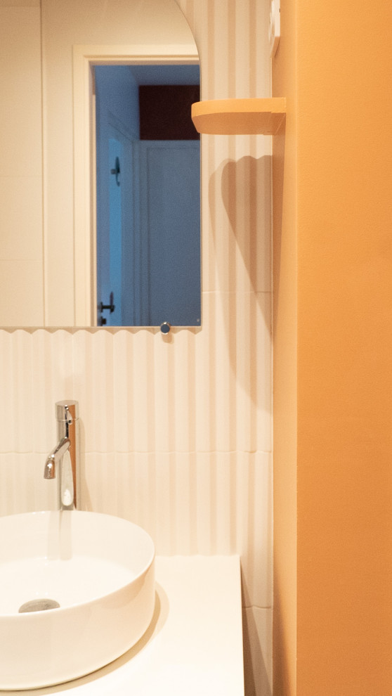 Idee per una stanza da bagno con doccia minimalista con doccia aperta, WC sospeso, piastrelle bianche, piastrelle in ceramica, pareti arancioni, pavimento in cementine, lavabo da incasso, top in laminato, top bianco e un lavabo
