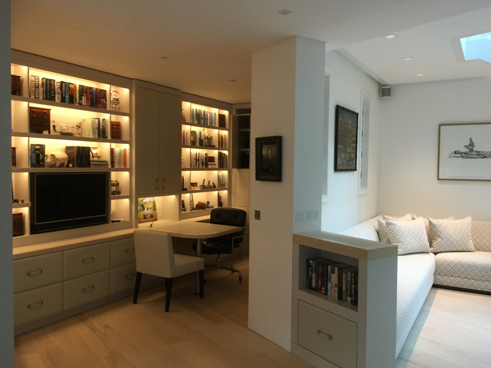 Immagine di un piccolo ufficio moderno con pareti bianche, parquet chiaro e scrivania incassata