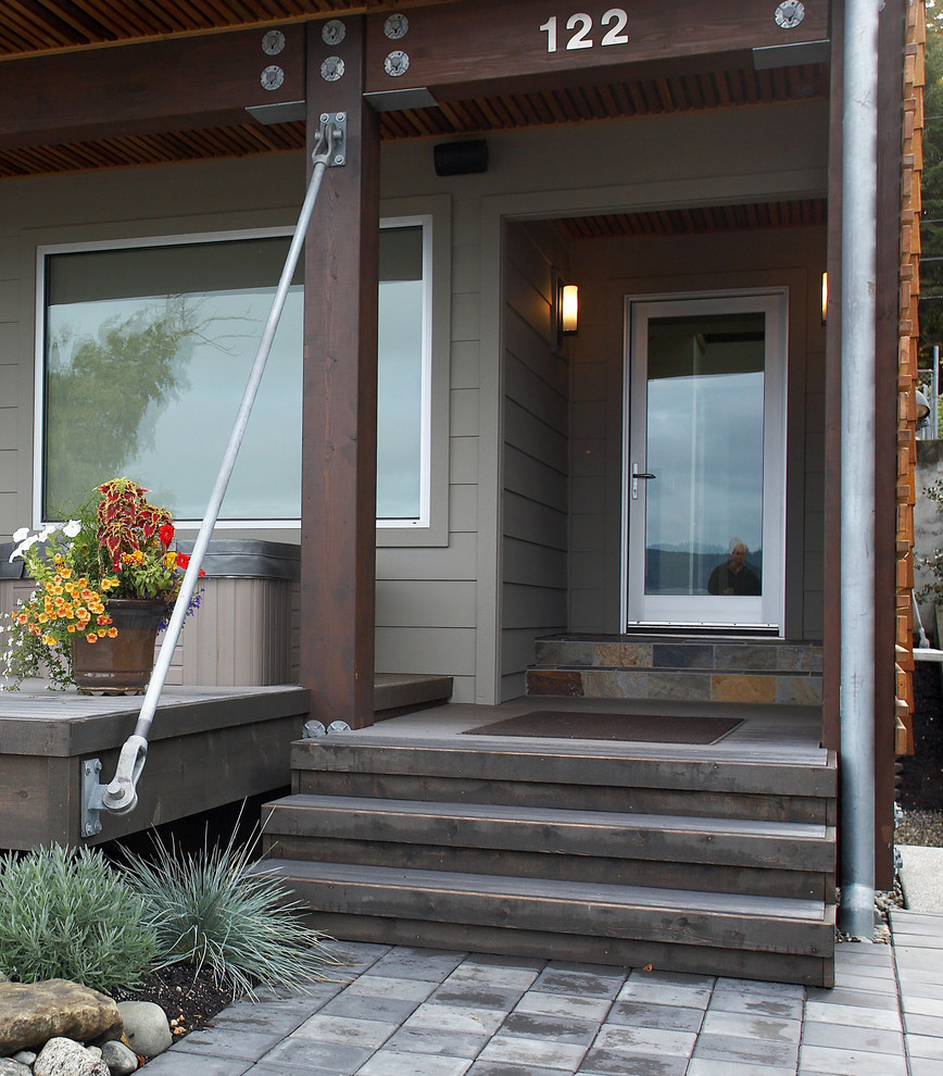 Photo of a mid-sized contemporary front door in Seattle with a single front door, a glass front door, multi-coloured walls, laminate floors and grey floor.