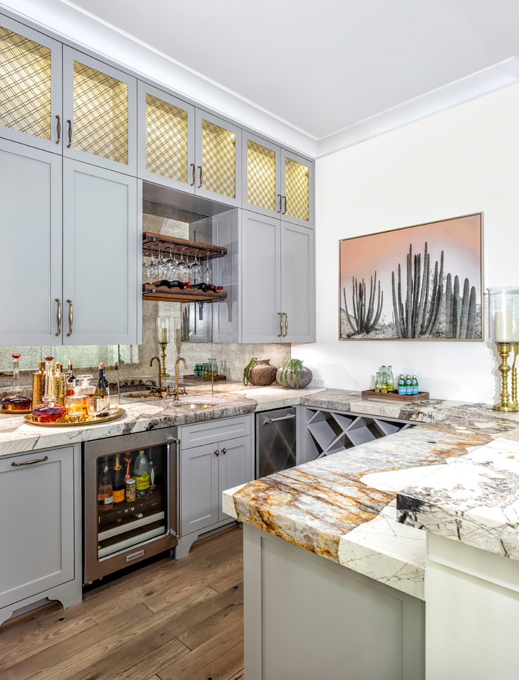 Wet bar - transitional u-shaped medium tone wood floor wet bar idea in Houston with an undermount sink, shaker cabinets, gray cabinets, mirror backsplash and multicolored countertops