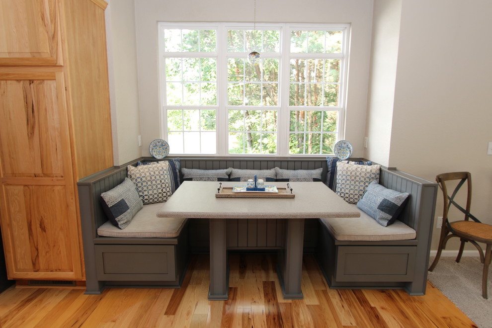 Mid-sized transitional light wood floor kitchen/dining room combo photo in Grand Rapids with beige walls, a standard fireplace and a wood fireplace surround