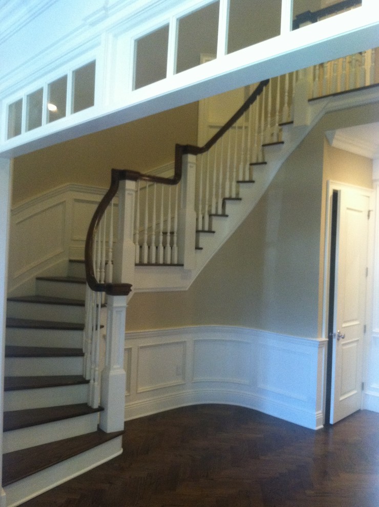 Example of a classic wooden curved staircase design in New York with wooden risers