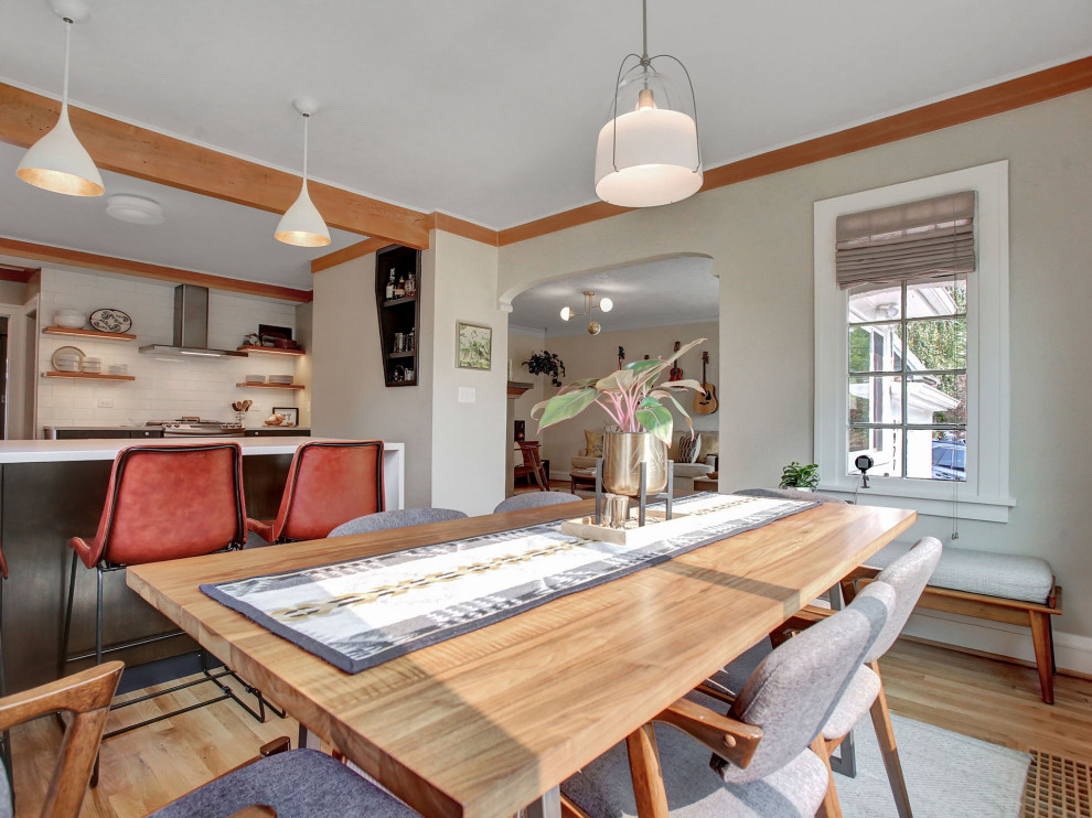 Bohemian kitchen/dining room in Portland with medium hardwood flooring, brown floors and exposed beams.