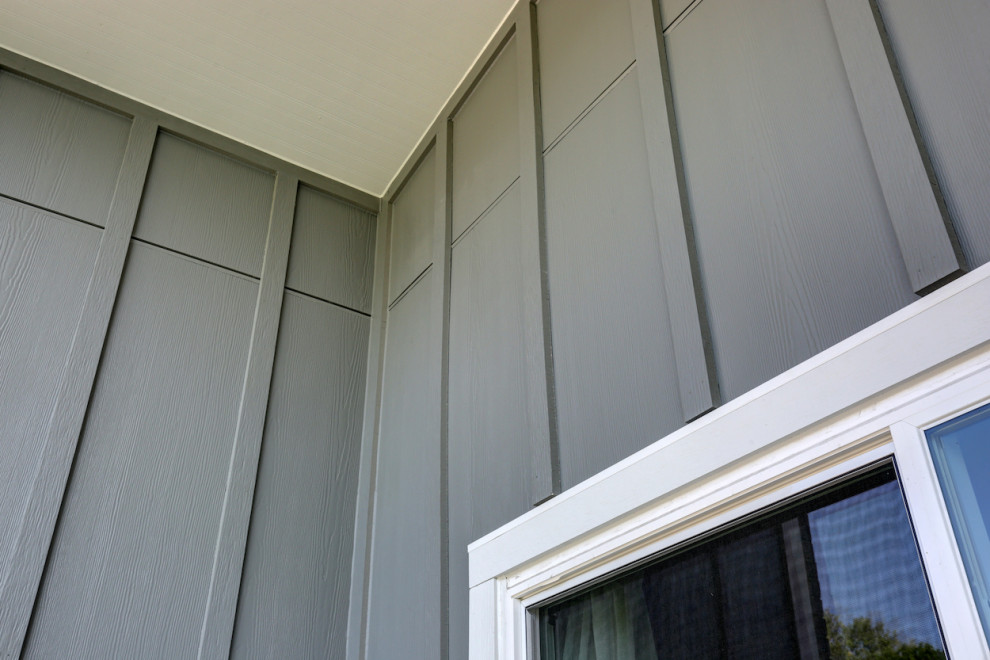 Imagen de fachada de casa gris y negra minimalista de tamaño medio de una planta con revestimiento de aglomerado de cemento, tejado a dos aguas, tejado de teja de madera y panel y listón