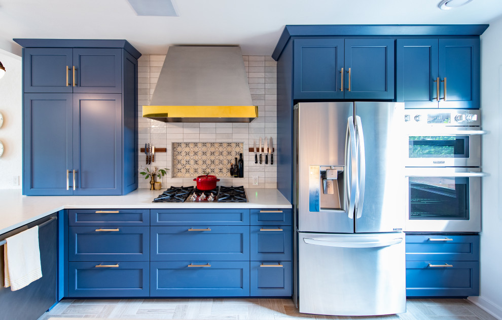 Design ideas for a small traditional u-shaped eat-in kitchen in Seattle with a farmhouse sink, shaker cabinets, blue cabinets, quartz benchtops, blue splashback, ceramic splashback, stainless steel appliances, ceramic floors, a peninsula, brown floor and white benchtop.