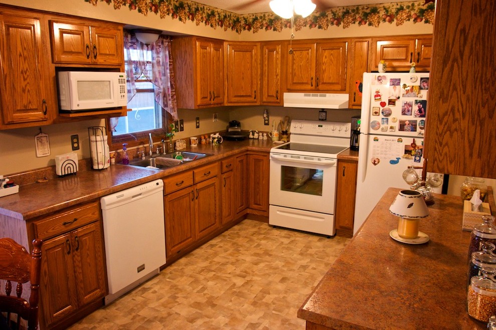 Inspiration for a small u-shaped eat-in kitchen remodel with raised-panel cabinets, medium tone wood cabinets, laminate countertops, white appliances and no island