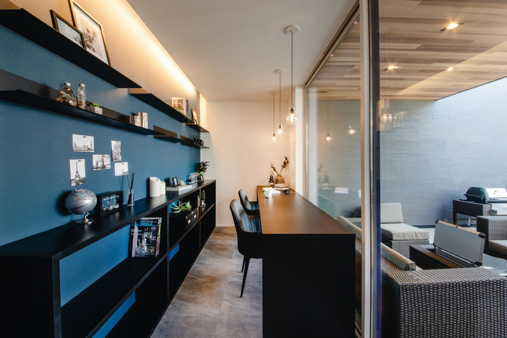 Modernes Arbeitszimmer mit blauer Wandfarbe, grauem Boden, Tapetendecke und Tapetenwänden in Sonstige