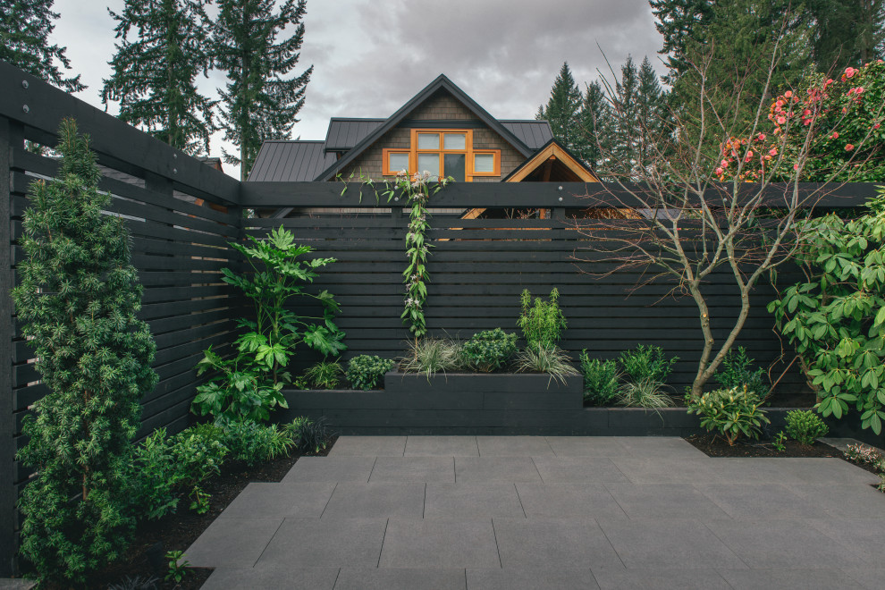 This is an example of a modern backyard partial sun garden in Vancouver with with raised garden bed.