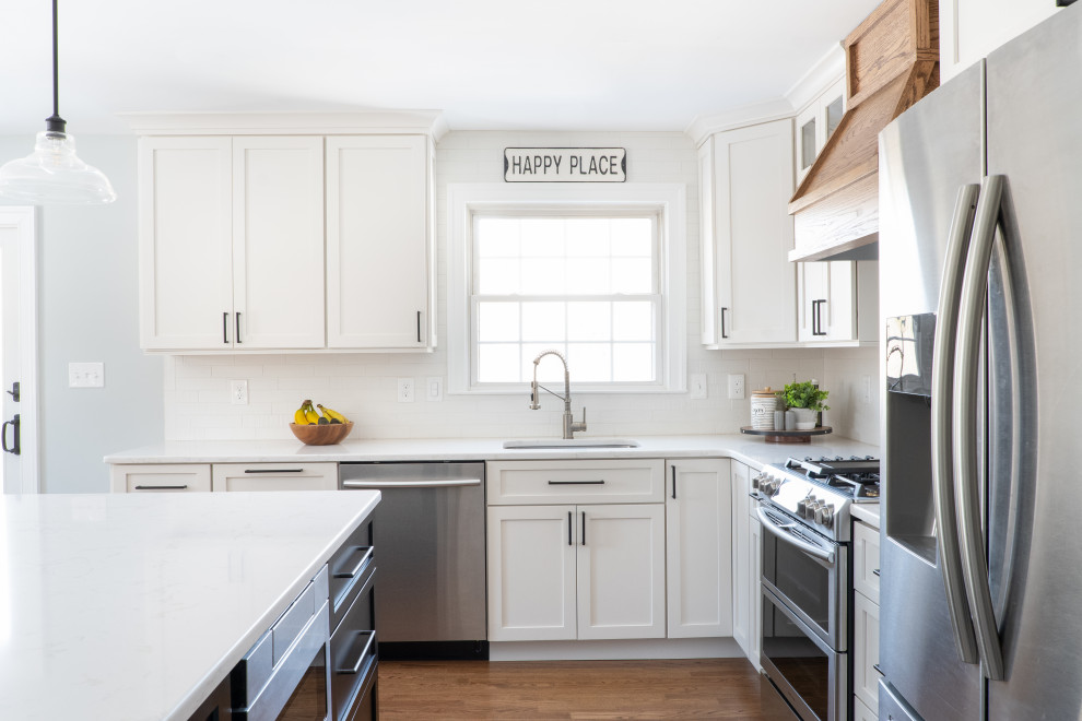 Exempel på ett mellanstort klassiskt vit vitt kök, med en undermonterad diskho, skåp i shakerstil, vita skåp, bänkskiva i kvarts, vitt stänkskydd, stänkskydd i porslinskakel, rostfria vitvaror, mellanmörkt trägolv, en köksö och brunt golv