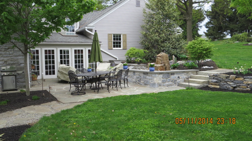 Photo of a country patio in Other with natural stone pavers.