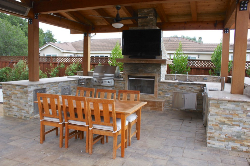 Photo of a large traditional backyard patio in San Francisco with an outdoor kitchen, natural stone pavers and a pergola.