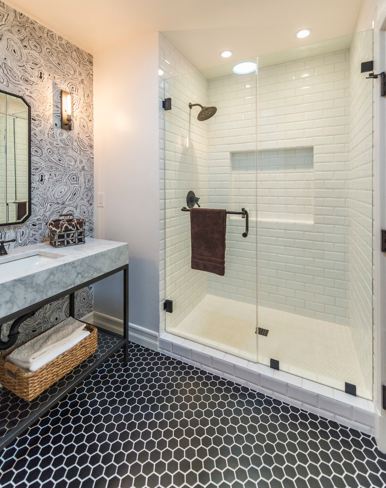This is an example of a mid-sized transitional 3/4 bathroom in Los Angeles with open cabinets, black cabinets, an alcove shower, white tile, subway tile, grey walls, mosaic tile floors, an undermount sink, marble benchtops, black floor, a hinged shower door and white benchtops.