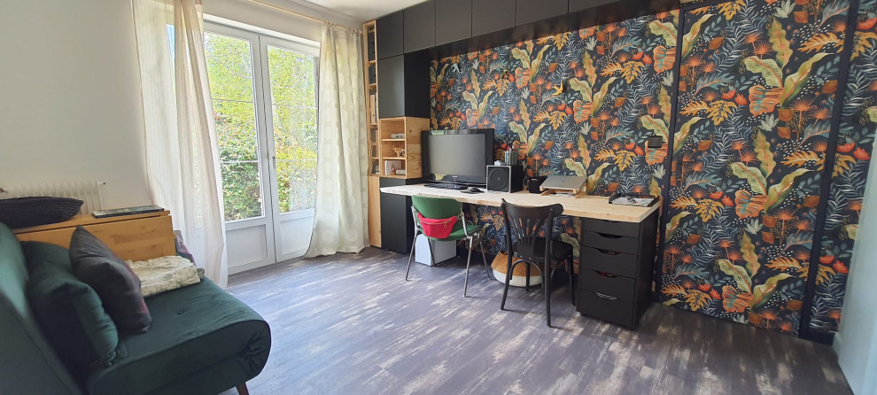 Mid-sized modern study room in Bordeaux with multi-coloured walls, vinyl floors, a built-in desk, black floor and wallpaper.