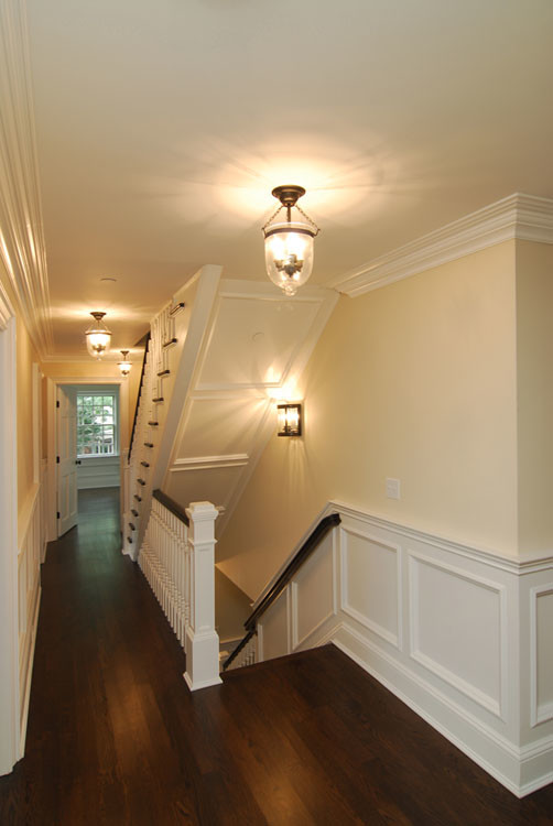 Photo of a mid-sized traditional hallway in New York with beige walls and dark hardwood floors.
