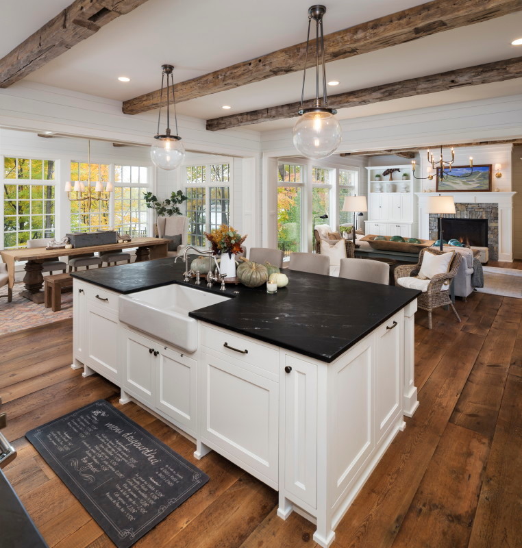 Design ideas for an eclectic open plan kitchen with a drop-in sink, white cabinets, granite benchtops, medium hardwood floors, with island and brown floor.