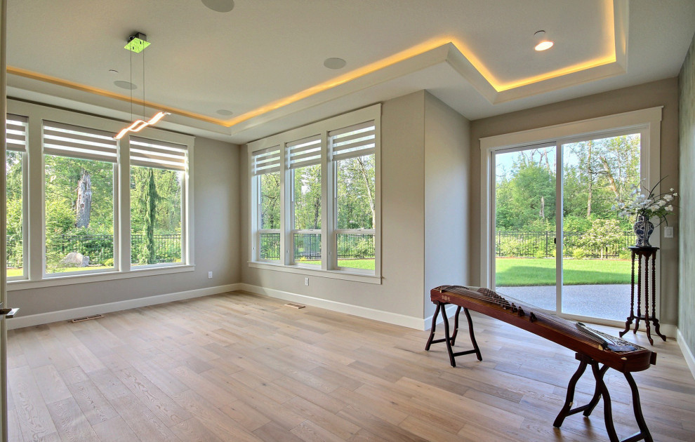 Geräumiges, Abgetrenntes Modernes Heimkino mit beiger Wandfarbe, hellem Holzboden, TV-Wand und braunem Boden in Portland