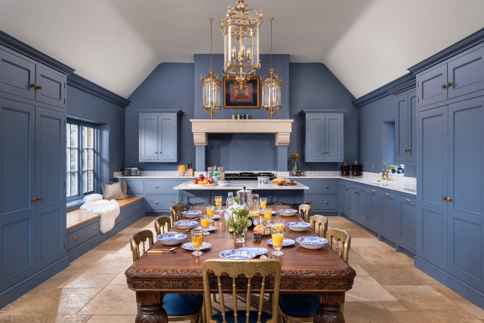 This is an example of a large eat-in kitchen in Oxfordshire with recessed-panel cabinets, blue cabinets, coloured appliances, limestone floors and beige floor.
