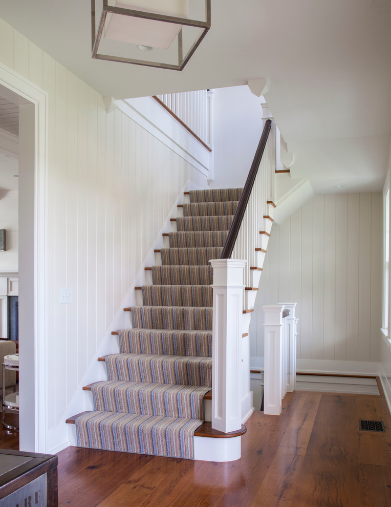 Mid-sized beach style wood l-shaped staircase in Boston with painted wood risers.
