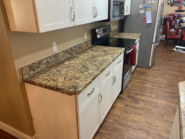 Mid-sized galley enclosed kitchen photo with shaker cabinets, white cabinets, laminate countertops, a peninsula and brown countertops