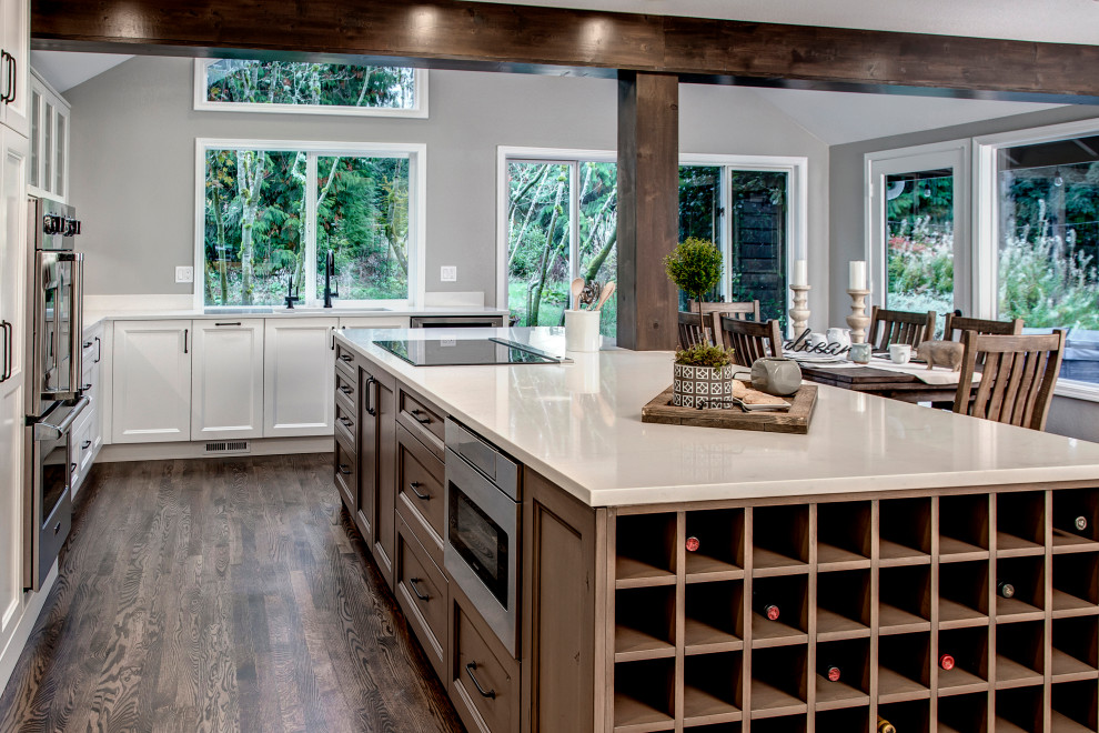 Design ideas for a large transitional eat-in kitchen in Seattle with an undermount sink, recessed-panel cabinets, yellow cabinets, quartz benchtops, grey splashback, ceramic splashback, stainless steel appliances, medium hardwood floors, with island, brown floor and white benchtop.