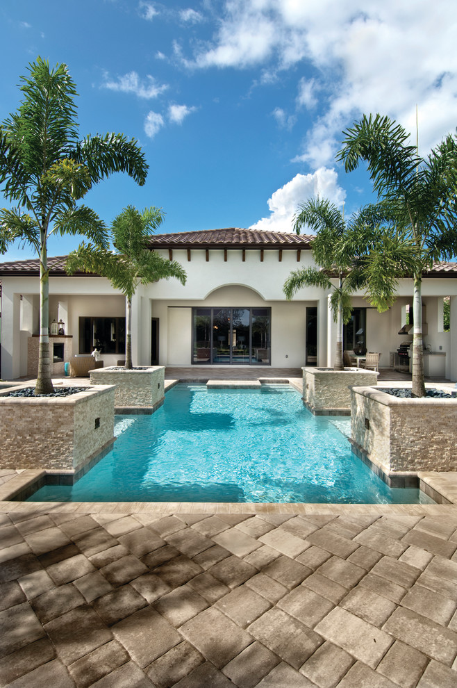 Photo of a large mediterranean one-storey stucco beige exterior in Miami with a hip roof.