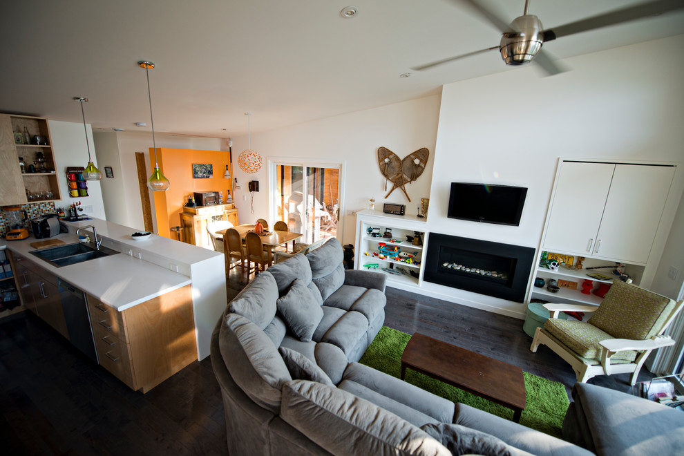 This is an example of a modern open concept living room in Minneapolis with orange walls, dark hardwood floors, a ribbon fireplace and a wall-mounted tv.