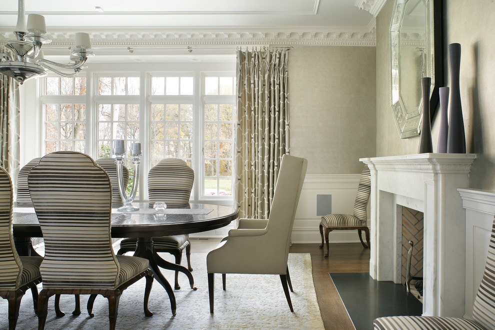 Example of a large classic dark wood floor enclosed dining room design in New York with beige walls and a standard fireplace
