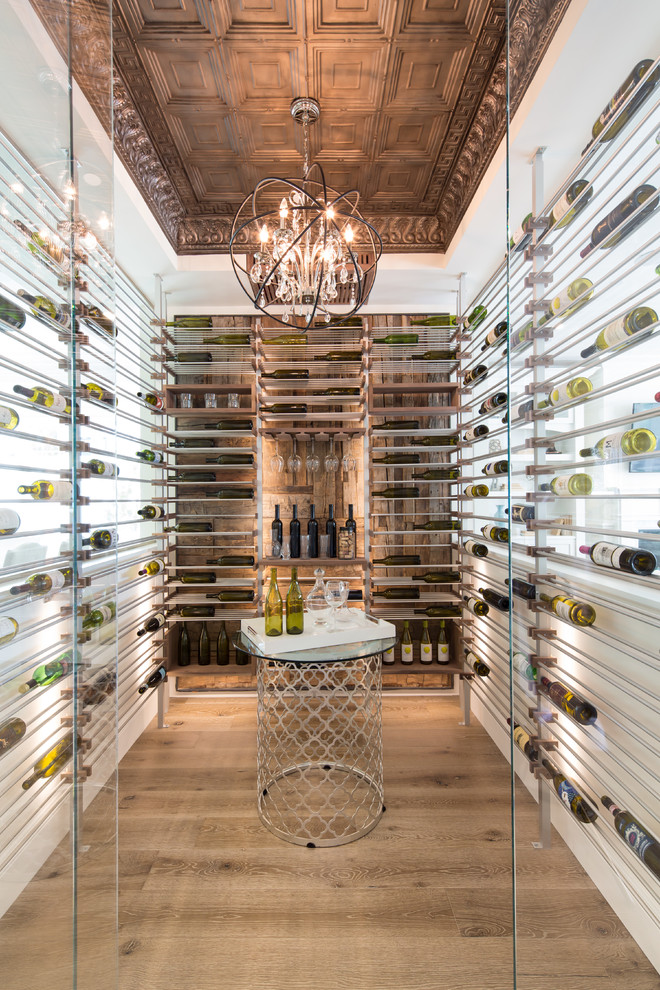 Photo of a mid-sized contemporary wine cellar in Los Angeles with light hardwood floors, storage racks and brown floor.