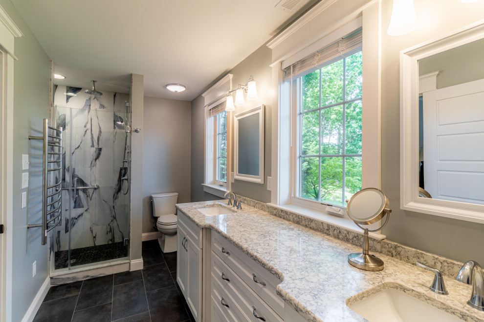 Photo of a mid-sized arts and crafts master bathroom in Baltimore with flat-panel cabinets, white cabinets, a corner shower, multi-coloured tile, cement tiles, a drop-in sink, granite benchtops, black floor, a hinged shower door, a double vanity and a built-in vanity.