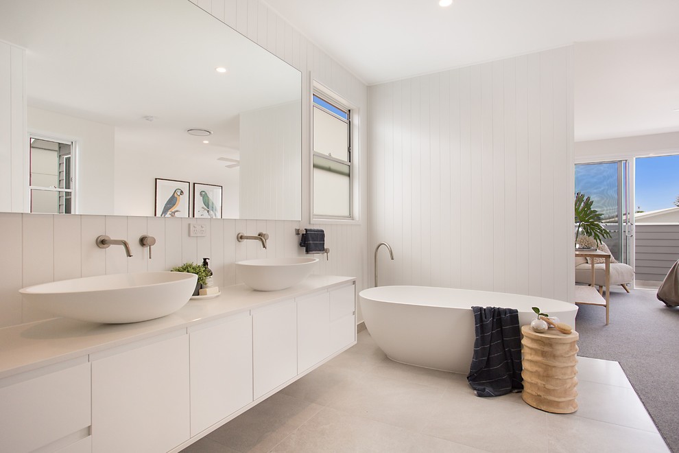 Contemporary bathroom in Gold Coast - Tweed with flat-panel cabinets, white cabinets, a freestanding tub, white walls, a vessel sink, white floor and white benchtops.