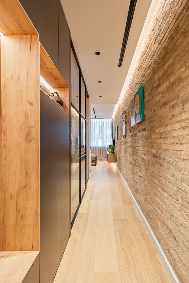 Идея дизайна: большой коридор в стиле лофт с паркетным полом среднего тона и кирпичными стенами