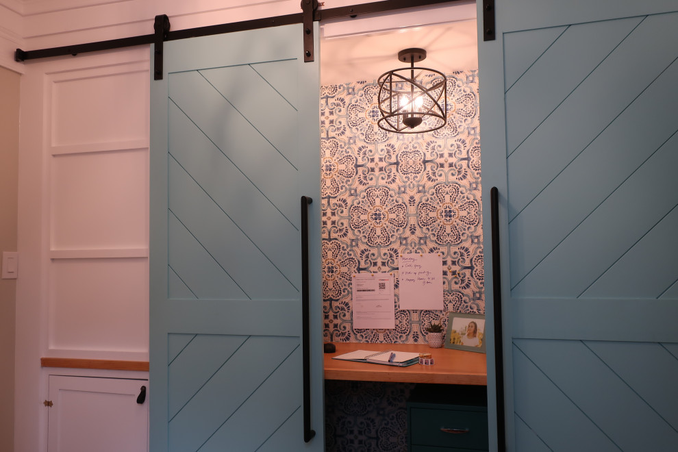 Diseño de despacho actual pequeño con paredes azules, escritorio empotrado y papel pintado