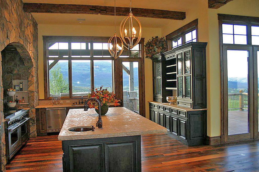 Eat-in kitchen - huge rustic u-shaped medium tone wood floor eat-in kitchen idea in Denver with an undermount sink, raised-panel cabinets, black cabinets, granite countertops, brown backsplash, stone slab backsplash, stainless steel appliances, yellow walls and an island