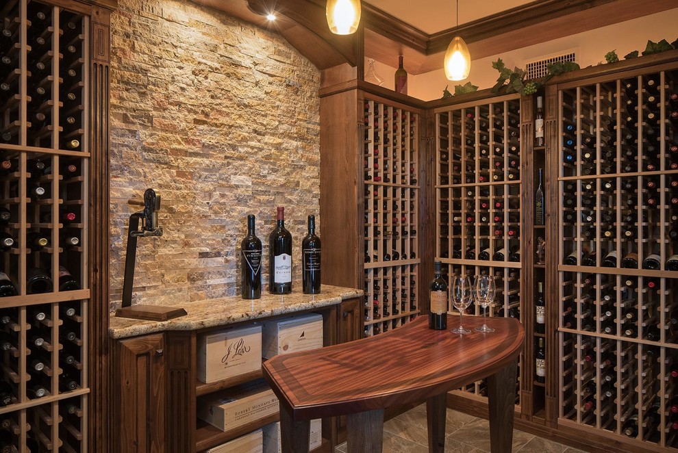 This is an example of a large traditional wine cellar in Phoenix with travertine floors and storage racks.