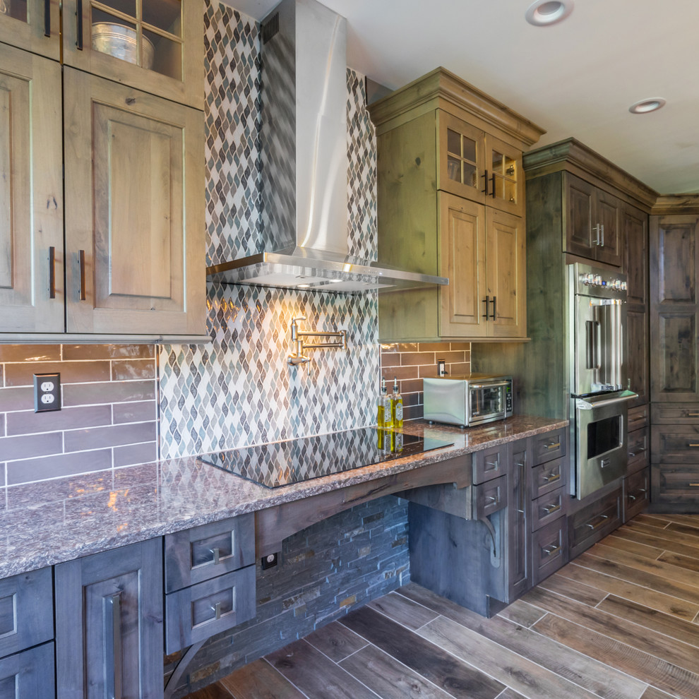 Design ideas for a large country l-shaped open plan kitchen in Philadelphia with a farmhouse sink, raised-panel cabinets, distressed cabinets, quartz benchtops, grey splashback, cement tile splashback, stainless steel appliances, porcelain floors, with island and brown floor.