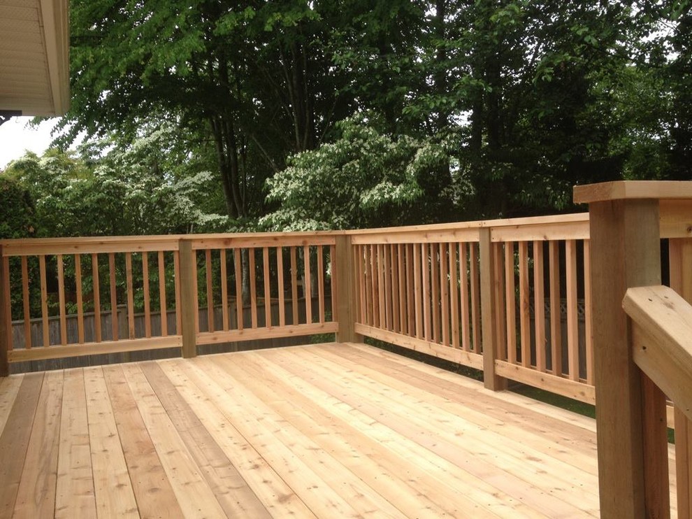 Example of a large backyard deck design in Vancouver with a pergola
