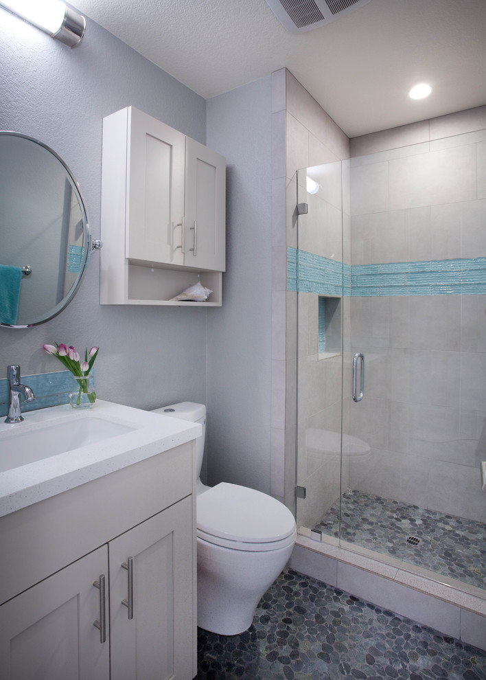 Mid-sized modern 3/4 bathroom in San Diego with flat-panel cabinets, grey cabinets, an alcove shower, a two-piece toilet, gray tile, grey walls, pebble tile floors, a trough sink, multi-coloured floor and a hinged shower door.